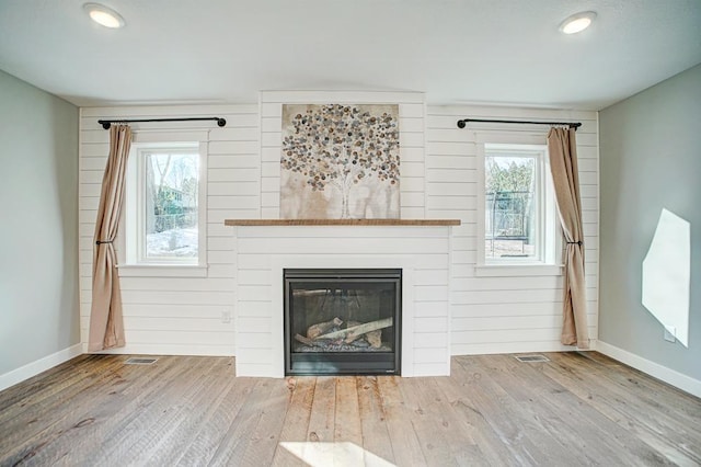 unfurnished living room with a healthy amount of sunlight and light hardwood / wood-style floors