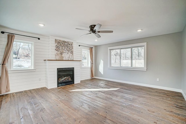 unfurnished living room featuring wood-type flooring and ceiling fan