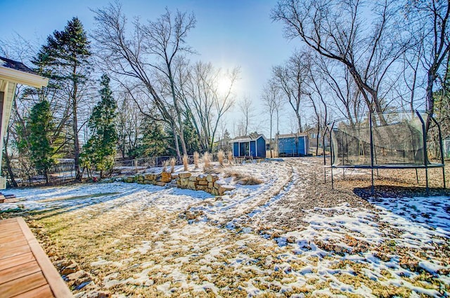 yard covered in snow featuring a trampoline