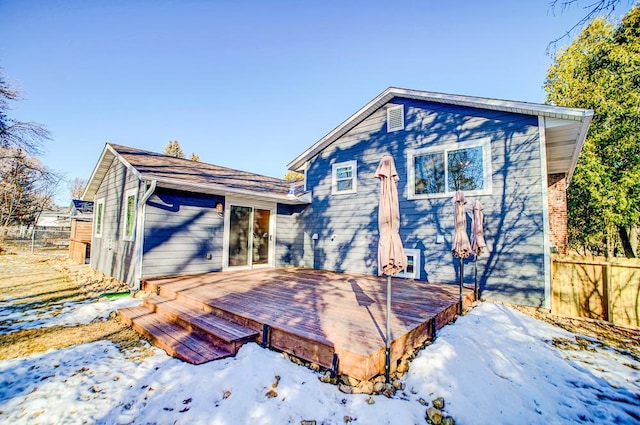 snow covered house featuring a wooden deck