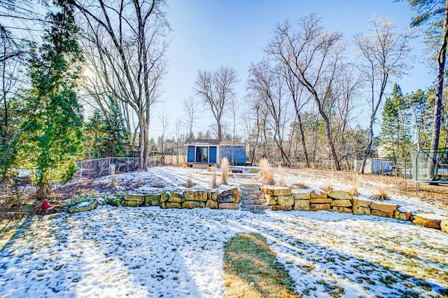 yard layered in snow with an outbuilding