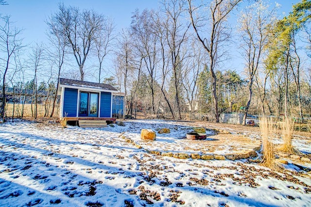 snowy yard with an outbuilding