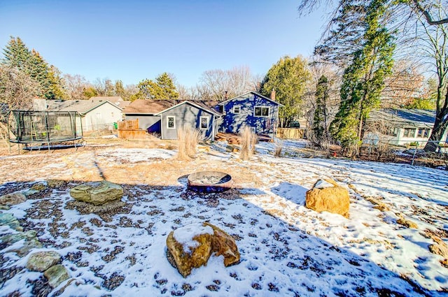 yard covered in snow featuring a trampoline