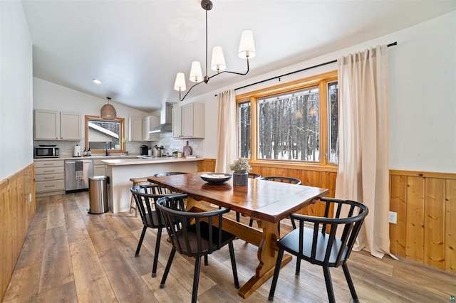 9505 Buskey Bay Dr, Iron River, WI 54847 - dining space with a wainscoted wall, healthy amount of natural light, light wood-type flooring, vaulted ceiling, and wooden walls