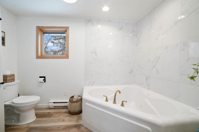 9505 Buskey Bay Dr, Iron River, WI 54847 - bathroom featuring baseboard heating, a tub with jets, wood finished floors, toilet, and baseboards