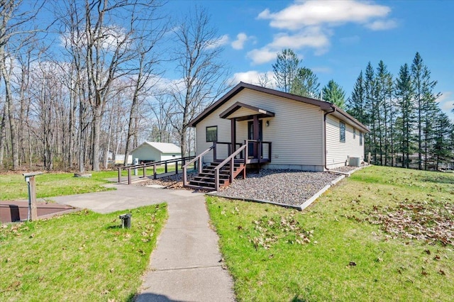 9505 Buskey Bay Dr, Iron River, WI 54847 - bungalow-style house with central AC unit and a front lawn