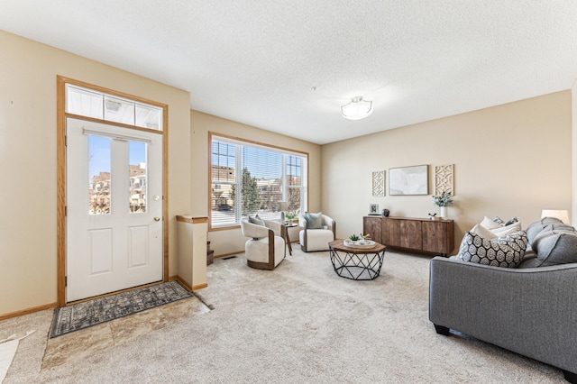 foyer entrance featuring baseboards, a textured ceiling, and light colored carpet