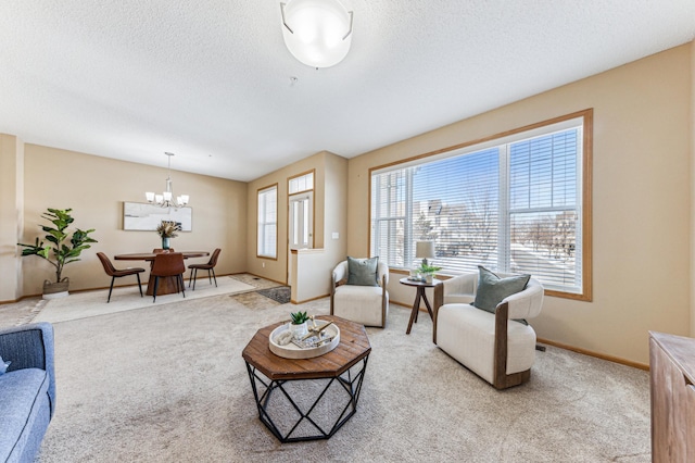 living room with an inviting chandelier, baseboards, a textured ceiling, and light colored carpet