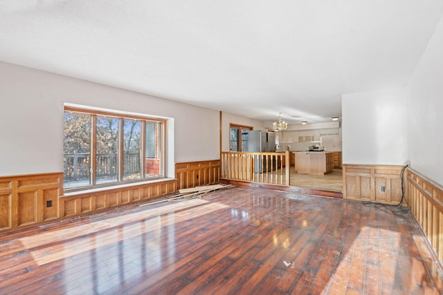 unfurnished room featuring an inviting chandelier and wood-type flooring