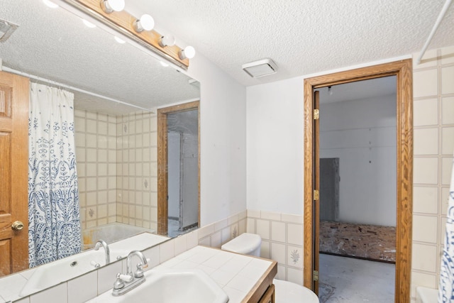 full bathroom featuring vanity, toilet, a textured ceiling, and shower / bath combo with shower curtain