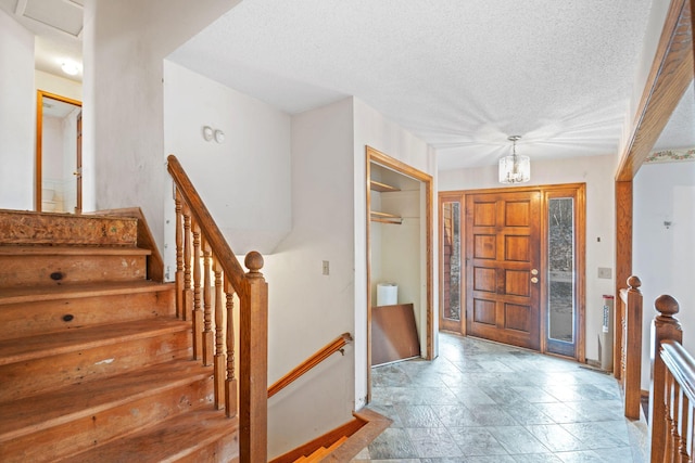 foyer featuring a chandelier and a textured ceiling