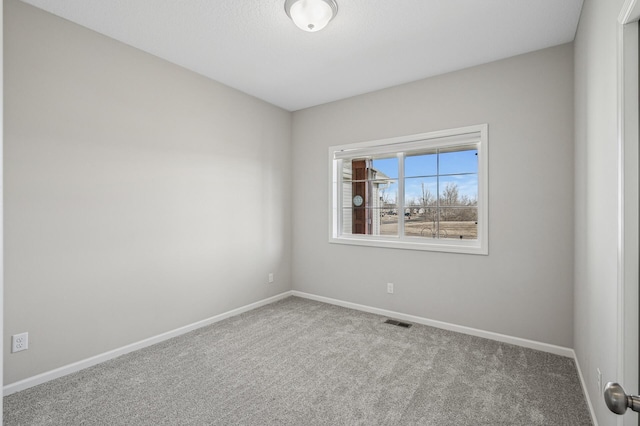 empty room with visible vents, baseboards, and carpet