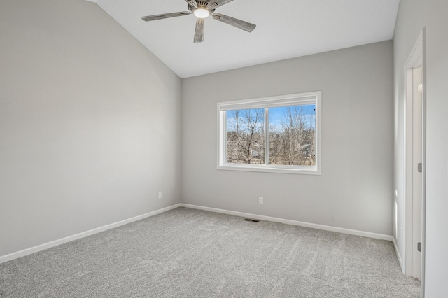 carpeted empty room with visible vents, baseboards, a ceiling fan, and vaulted ceiling