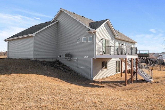 back of house with roof with shingles, a yard, central AC, stairs, and a deck