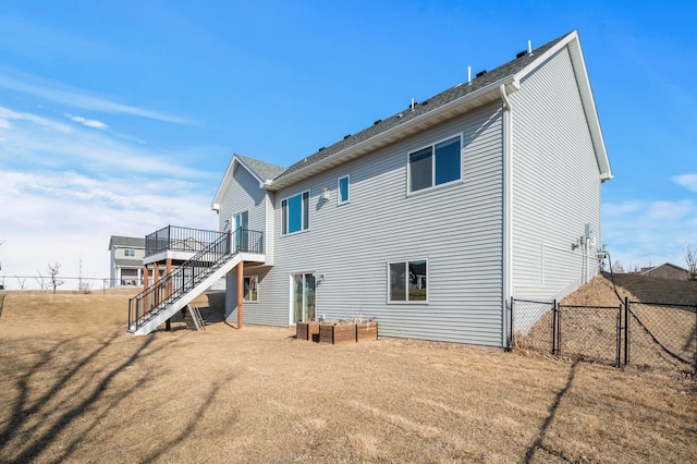 back of property featuring a lawn, a deck, stairs, and fence