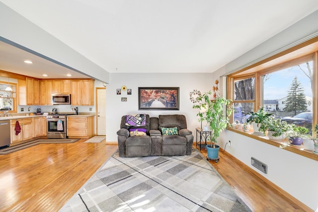 living room with sink and light wood-type flooring