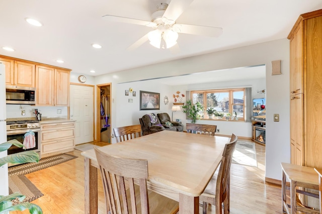 dining space featuring ceiling fan and light wood-type flooring