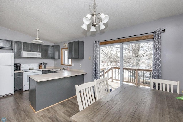 kitchen featuring dark wood-type flooring, sink, hanging light fixtures, kitchen peninsula, and white appliances