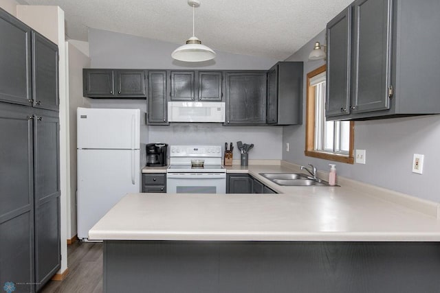 kitchen with sink, decorative light fixtures, vaulted ceiling, kitchen peninsula, and white appliances