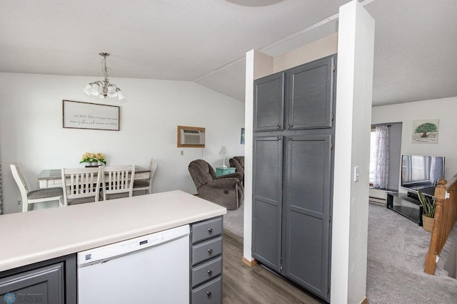 kitchen with lofted ceiling, decorative light fixtures, gray cabinets, dishwasher, and a notable chandelier