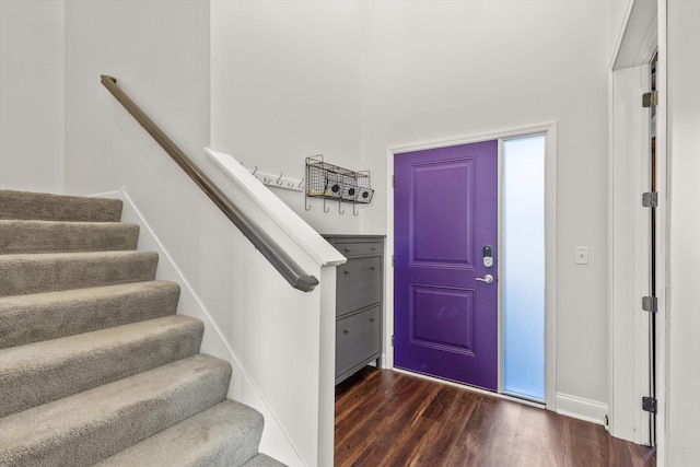 entrance foyer featuring stairway, dark wood-type flooring, and baseboards