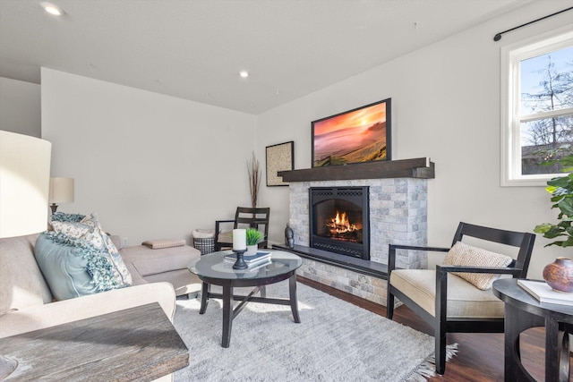 living area featuring recessed lighting, a stone fireplace, and wood finished floors