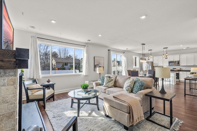 living area with dark wood-type flooring, recessed lighting, and baseboards