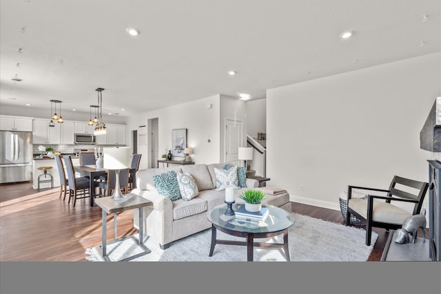 living area with recessed lighting, stairway, baseboards, and wood finished floors