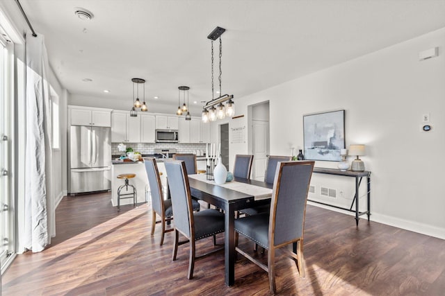 dining room with visible vents, dark wood-style floors, and baseboards