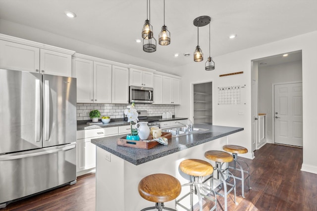 kitchen with dark countertops, white cabinetry, appliances with stainless steel finishes, and tasteful backsplash