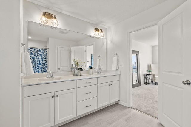 full bath featuring double vanity, curtained shower, baseboards, and a sink