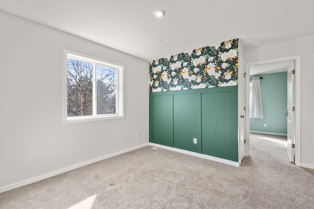 unfurnished bedroom with wallpapered walls, carpet, and baseboards