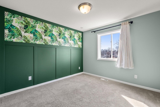 carpeted spare room with baseboards and visible vents