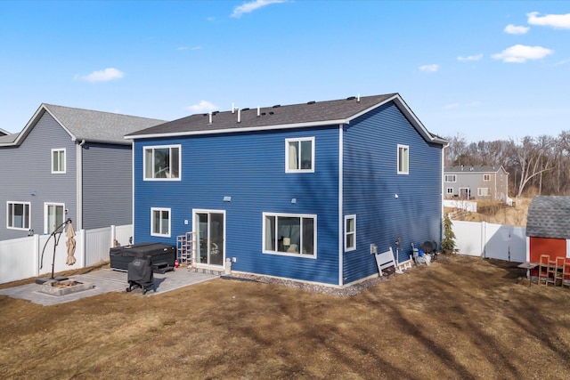 back of property featuring a patio, a fenced backyard, a lawn, and a hot tub