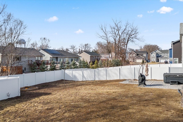 view of yard with a patio, a fenced backyard, and a residential view