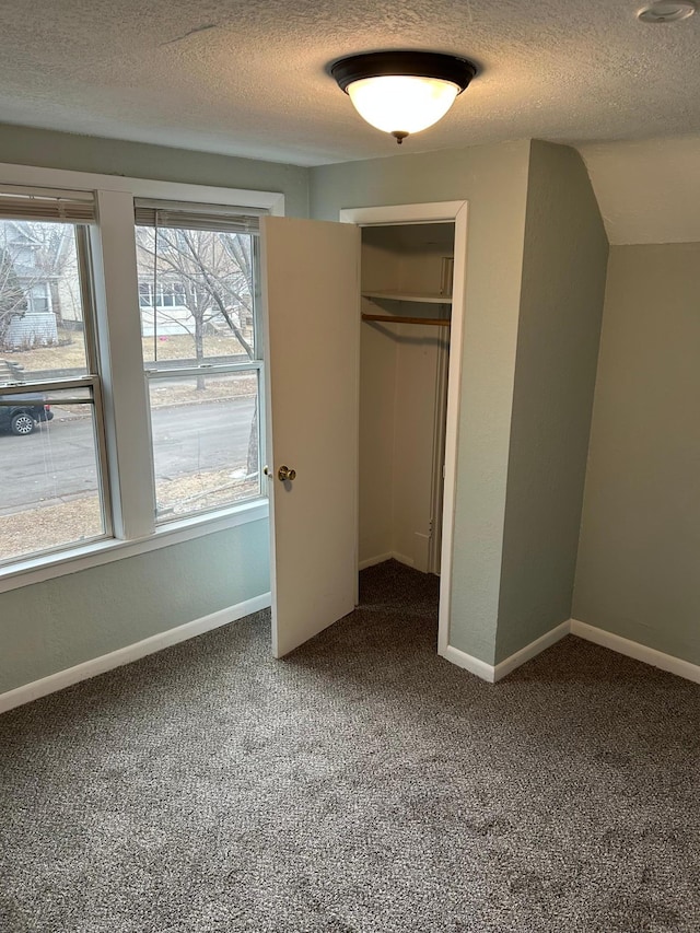 unfurnished bedroom featuring carpet floors, a textured ceiling, and a closet