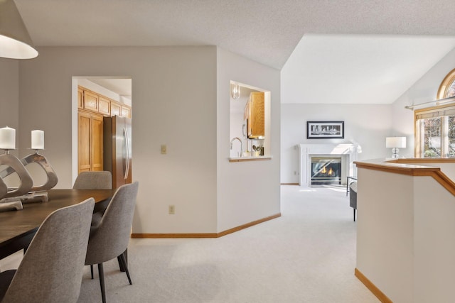 dining room featuring lofted ceiling and light carpet