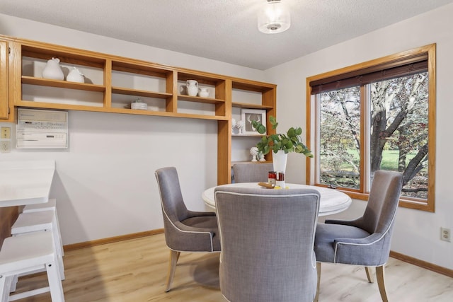 dining space featuring a textured ceiling and light hardwood / wood-style floors