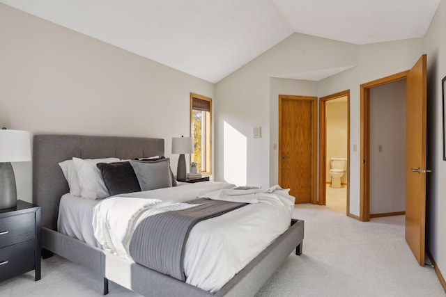 carpeted bedroom featuring vaulted ceiling and ensuite bathroom