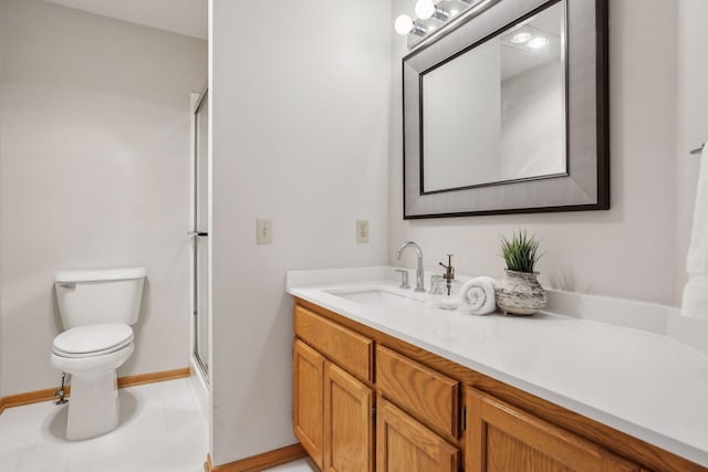 bathroom with vanity, a shower with shower door, and toilet