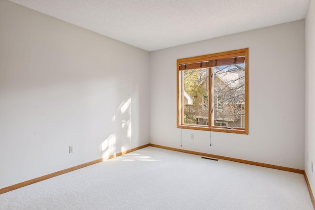 carpeted spare room with a textured ceiling