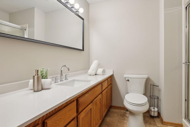 bathroom with vanity, a shower with door, and toilet