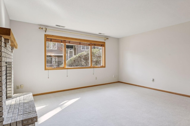 carpeted spare room with a fireplace