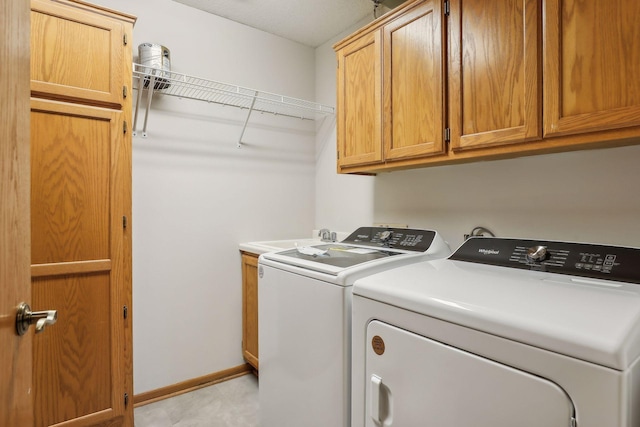 laundry room featuring cabinets, washing machine and clothes dryer, and sink