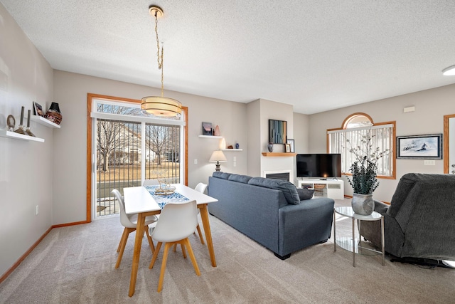 dining area with light colored carpet and a textured ceiling