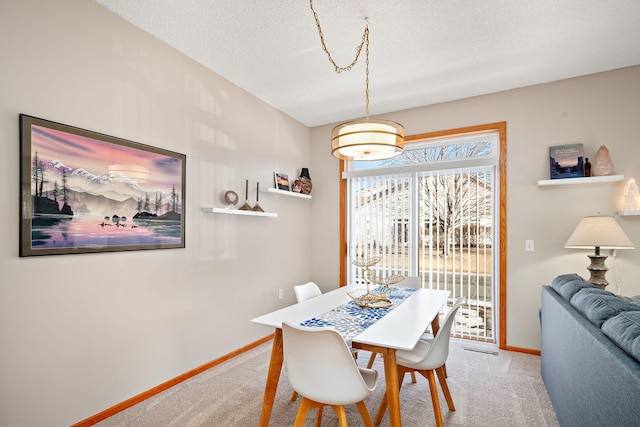 carpeted dining room with a textured ceiling