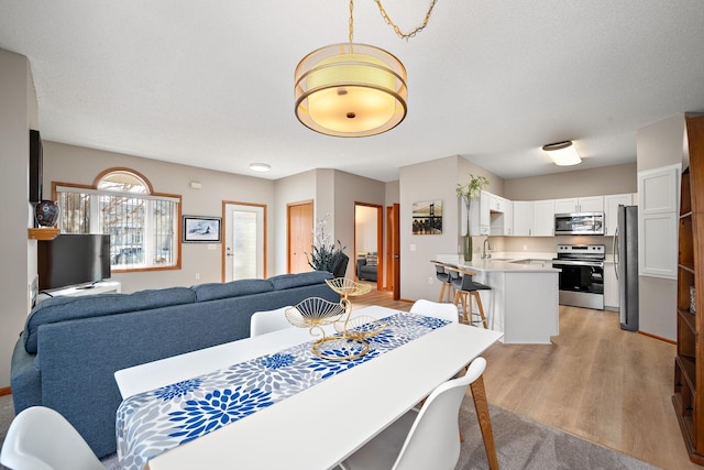 dining area with sink and light hardwood / wood-style flooring