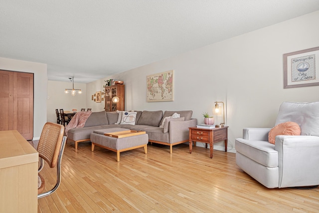 living room with an inviting chandelier and light wood-type flooring