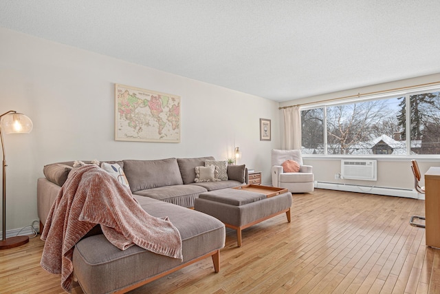 living room with a baseboard radiator, a wall mounted AC, a textured ceiling, and light wood-type flooring