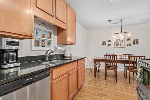 kitchen with sink, dark stone counters, hanging light fixtures, stainless steel appliances, and light hardwood / wood-style flooring